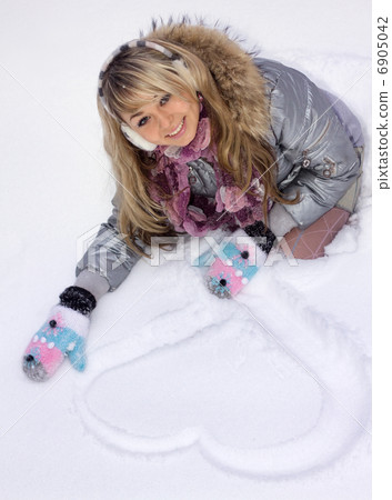 young smiling woman draw heart on snow young smiling woman draw heart on snow 6905042