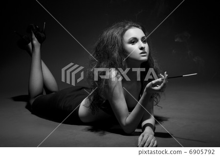 woman smokes in the dark. studio shot. BW Image woman smokes in the dark. studio shot. BW Image 6905792