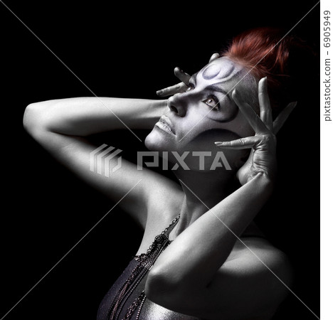 Portrait of beautiful woman with silver bodyart on black backgro 6905949