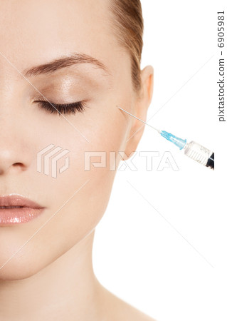 Beautiful woman gets an injection in her face isolated on white Beautiful woman gets an injection in her face isolated on white 6905981