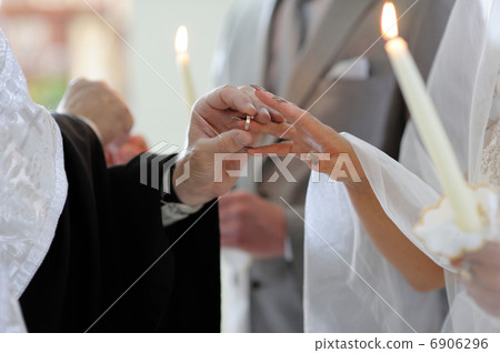 Priest putting the ring on brides finger Priest putting the ring on brides finger 6906296