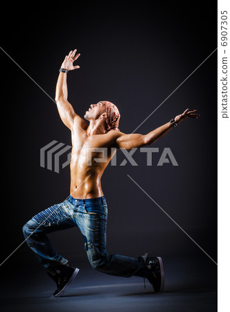 Dancer dancing in dark room 6907305