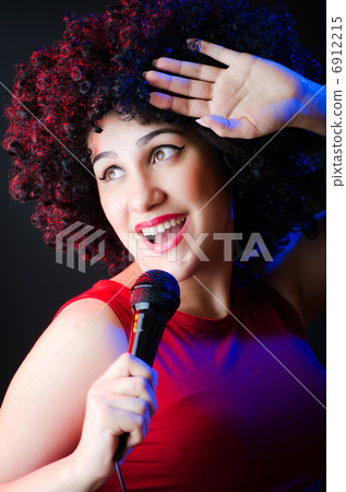 Female performer at disco with mic 6912215