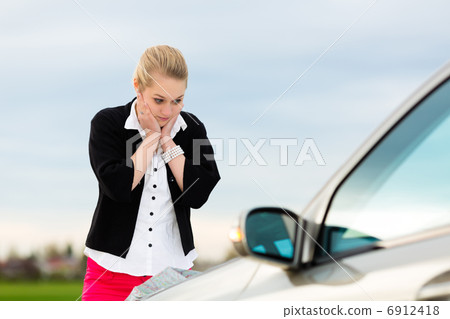 Young woman with map on car being lost 6912418