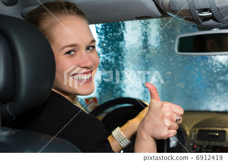 Young woman drives car in wash station Young woman drives car in wash station 6912419