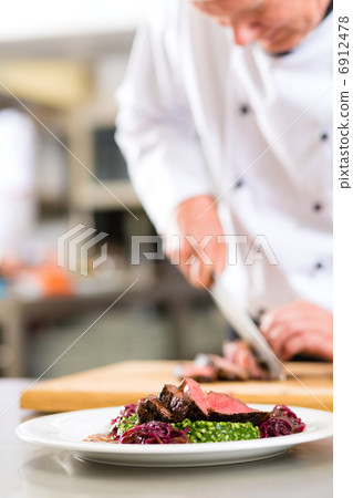 Chef in restaurant kitchen preparing food Chef in restaurant kitchen preparing food 6912478