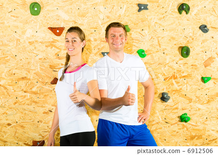 Woman and man standing at climbing wall 6912506