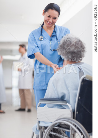 Doctor greeting recovering senior patient in wheelchair Doctor greeting recovering senior patient in wheelchair 6922563