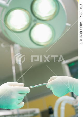 Nurse giving surgical scissor during an operation 6922593