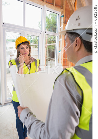 Architect and woman discussing blueprint Architect and woman discussing blueprint 6922595