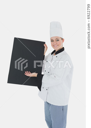 Female chef in uniform displaying black billboard Female chef in uniform displaying black billboard 6922799