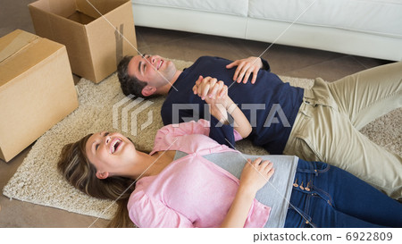 Laughing couple lying on floor with moving boxes 6922809