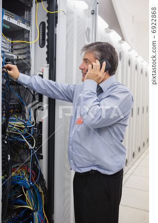 Man fixing wires while making a phone call Man fixing wires while making a phone call 6922868