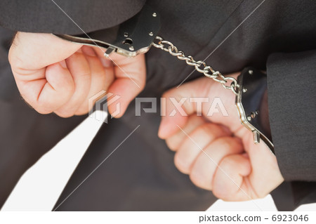 Businessman with handcuffs clencing fists 6923046