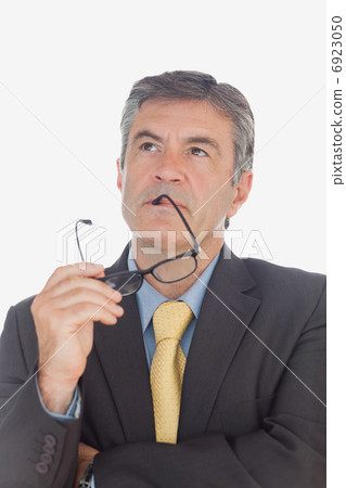 Thoughtful businessman with glasses looking up 6923050