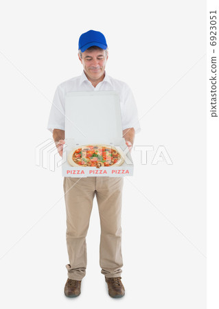 Mature delivery man looking at fresh pizza Mature delivery man looking at fresh pizza 6923051
