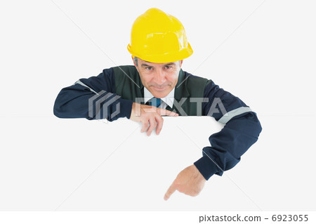 Confident repairman pointing at billboard 6923055