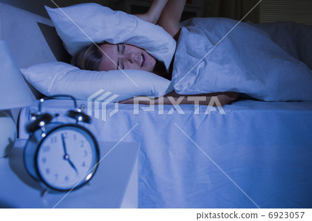 Blond woman putting pillows on her ears Blond woman putting pillows on her ears 6923057