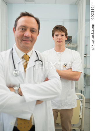 Doctor and a male nurse crossing their arms 6923164