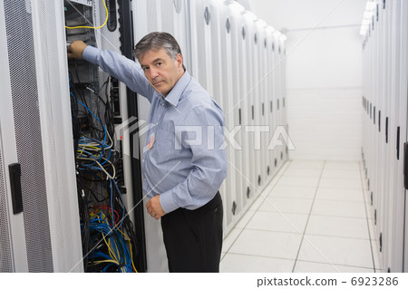 Man fixing wires of servers Man fixing wires of servers 6923286