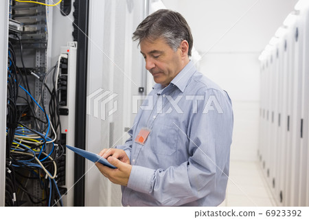 Technician checking the server with tablet pc Technician checking the server with tablet pc 6923392