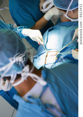 Surgeon performing an operation on a stomach Surgeon performing an operation on a stomach 6923452