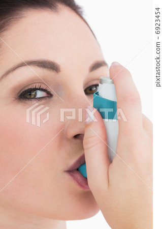 Happy woman using asthma inhaler 6923454