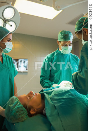Team of surgeons working on a female patient Team of surgeons working on a female patient 6923458
