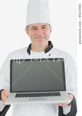 Happy male chef presenting laptop 6923460