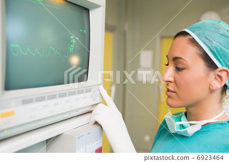 Smiling female surgeon standing next to a monitor Smiling female surgeon standing next to a monitor 6923464