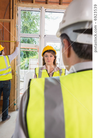 Woman looking upset at architect while man is measuring Woman looking upset at architect while man is measuring 6923539