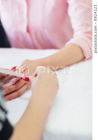 Woman filing fingernail 6924121
