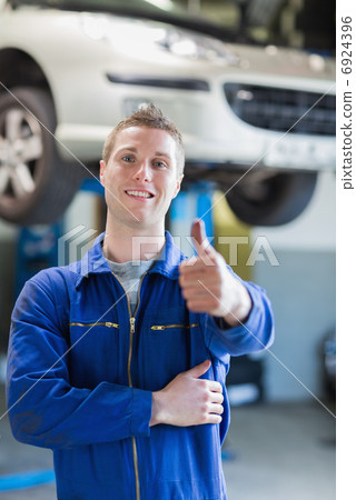 Happy male mechanic gesturing thumbs up Happy male mechanic gesturing thumbs up 6924396