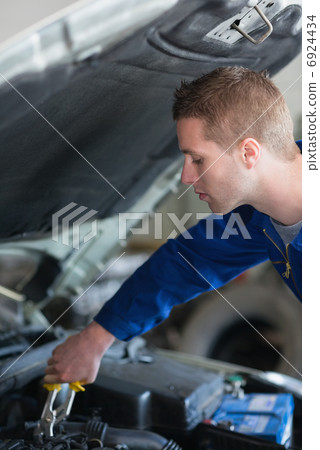 Car mechanic adjusting engine Car mechanic adjusting engine 6924434