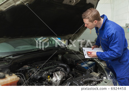 Mechanic writing on clipboard 6924458
