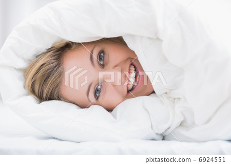Happy woman hiding under the duvet Happy woman hiding under the duvet 6924551
