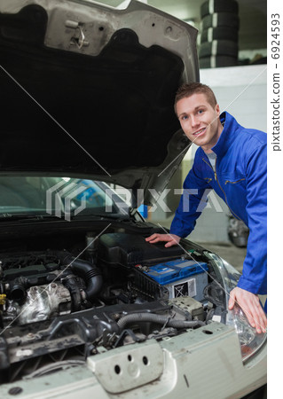 Happy mechanic repairing car engine 6924593
