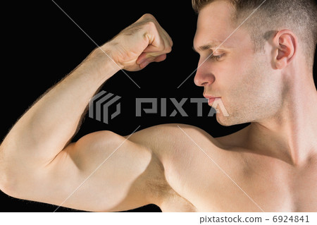 Close-up of young man flexing muscles 6924841