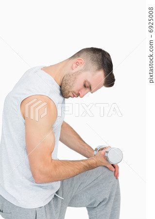 Side view of young man exercising with dumbbell 6925008