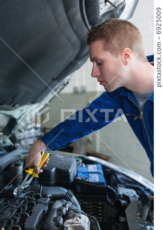 Mechanic working on car engine 6925009