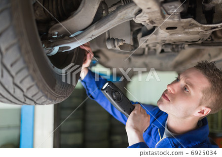 Mechanic examining tire Mechanic examining tire 6925034