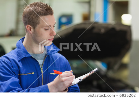 Mechanic writing on clipboard 6925202