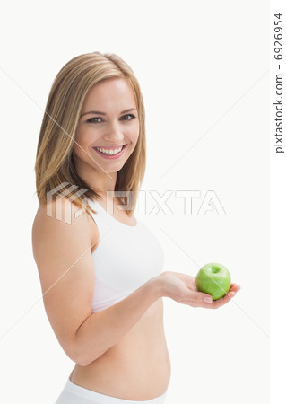 Portrait of happy young woman holding green apple Portrait of happy young woman holding green apple 6926954