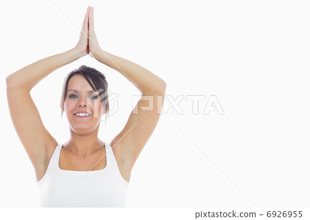 Portrait of smiling woman joining hands over head 6926955
