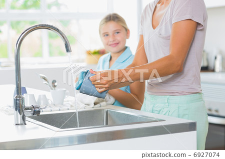 Mother doing the washing up Mother doing the washing up 6927074