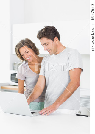 Cheerful couple using laptop 6927630