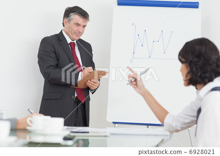 Businessman writing on clipboard in office 6928021