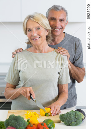 Joyful couple cutting a pepper 6928090