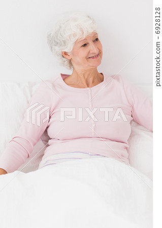 Happy woman sitting in bed Happy woman sitting in bed 6928128