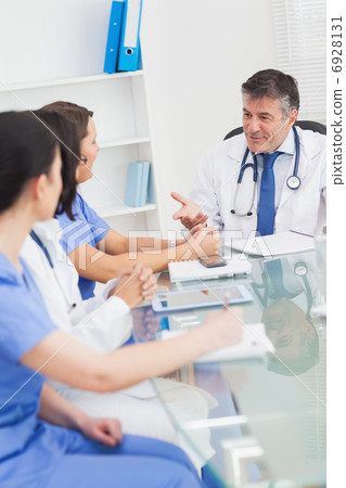 Meeting between a doctor and three nurses smiling Meeting between a doctor and three nurses smiling 6928131